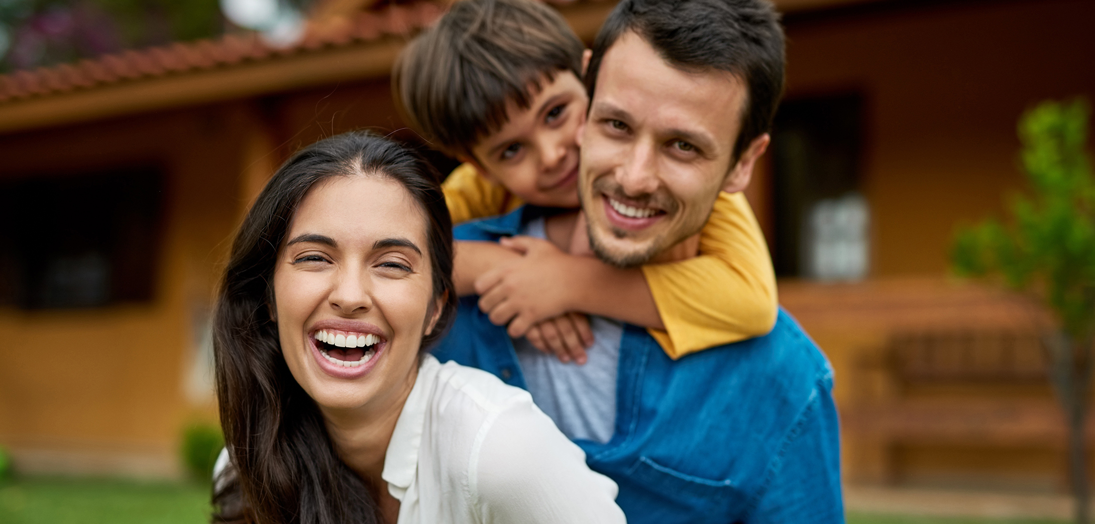 smiling family mom dad son backyard