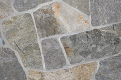 A bi-color gray stone running the range of dark gray with a lot of brown shading to an almost white-gray with very little brown. Our most popular stone. We highly recommend that you purchase all of this stone you will need for the entire project due to the considerable variation in color. Hand-Split Thin Veneer ranges in thickness from 1" to 3" with a nominal face range of 6" to 18". Average coverage is approximately 100 to 110 square feet per ton. A brick ledge of 4" to 6" is recommended when laying this product as a facade. Packaged in 1-ton Pallets